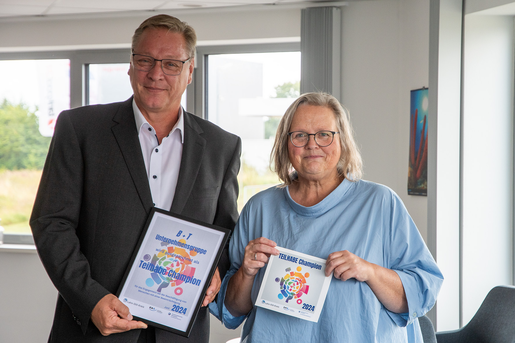 Urkundenübergabe für den „Teilhabechampion des Monats“: Frank Benner, CEO B+T Unternehmensgruppe und Monika Mundt, Einheitliche Ansprechstelle für Arbeitgeber im Lahn-Dill-Kreis. Foto: B+T Unternehmensgruppe