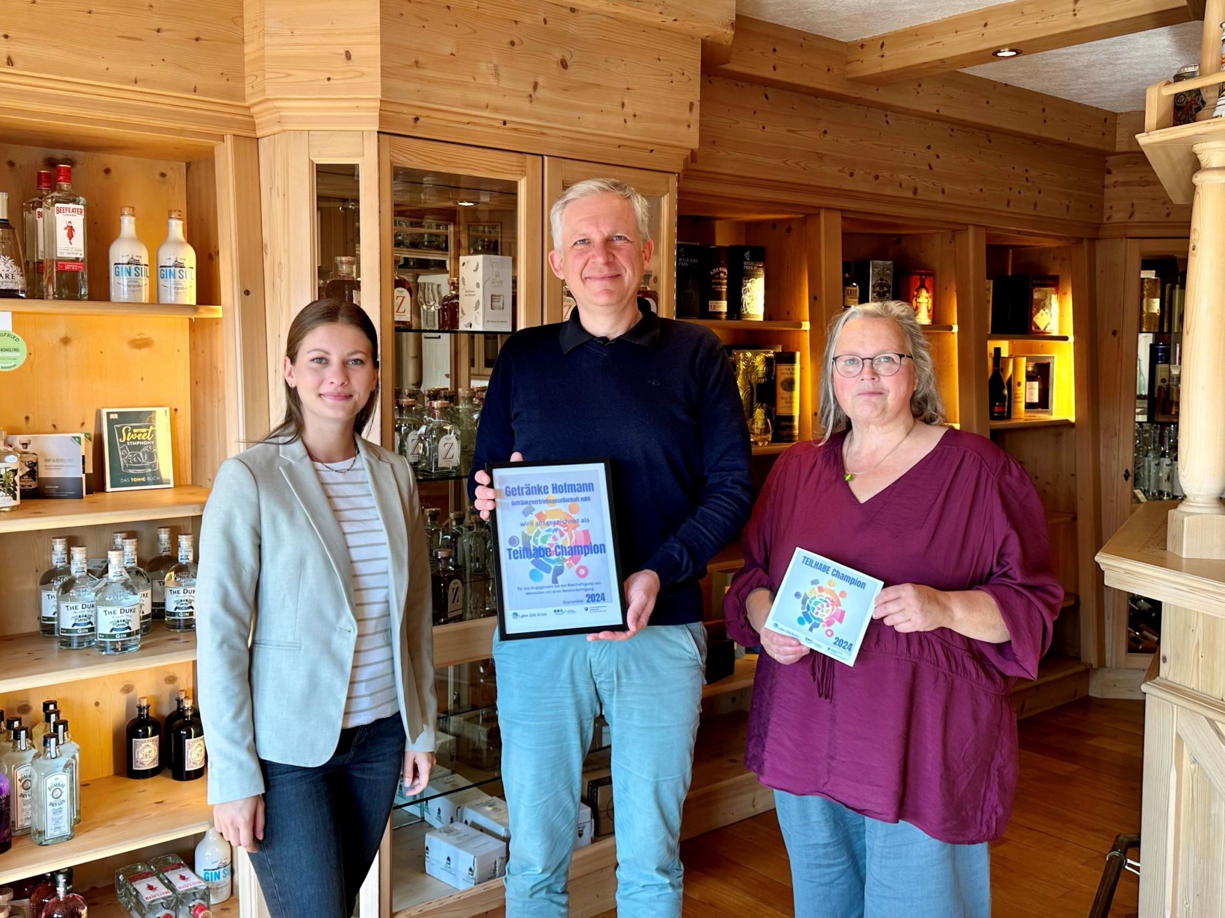 Kim Stahl (links) und Monika Mundt (rechts) freuen sich, Thorsten Hofmann und sein Unternehmen mit dem Titel „Teilhabechampion des Monats“ auszeichnen zu können. Foto: Lahn-Dill-Kreis